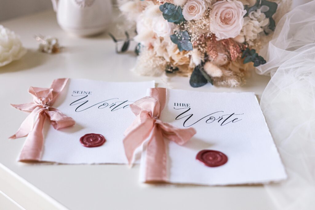 Stylish wedding invitations with pink ribbons and floral accents for a romantic occasion.